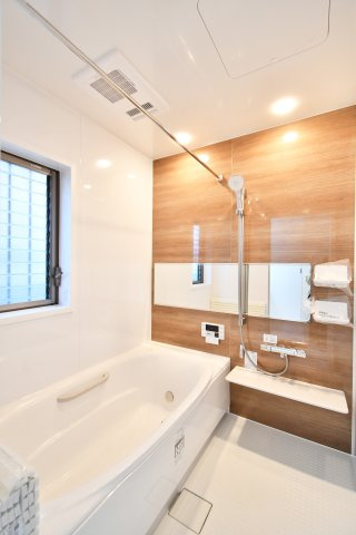さいたま市見沼区深作2丁目の浴室|木目調パネルが落ち着きのある雰囲気演出する、新規交換済みのユニットバス。ゆったり寛げる浴槽と横長ミラー、雨の日の洗濯に重宝する浴室乾燥機付き。窓からの自然光を感じながら、至福のバスタイムを。