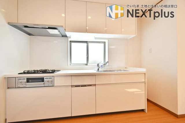 さいたま市見沼区深作2丁目のキッチン|機能美を追求したキッチンには、手元を明るく照らす窓付き。三口コンロで効率よく調理ができ、上下の大容量収納でキッチン周りもスッキリ片付きます。リフォーム完成済みの美しさをぜひ現地で体感ください。