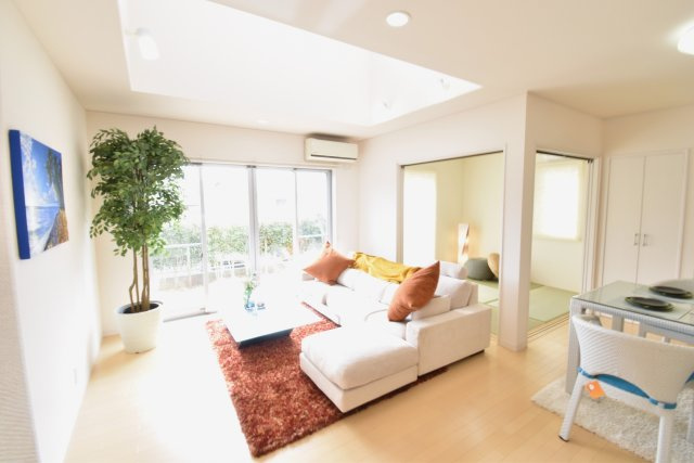 南ひな壇に建つ収納充実のモダン住宅の居間・リビング|白を基調としたLDK+吹き抜けは家族が自然と寛げる場所にピッタリです。光あふれるリビング空間と、タタミコーナー、スタディーカウンター等、家族がもっと触れ合える空間です。