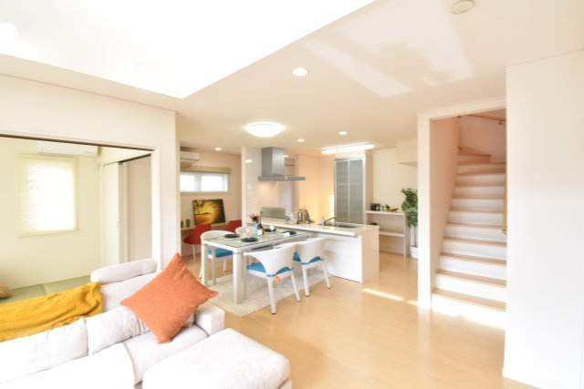 南ひな壇に建つ収納充実のモダン住宅の居間・リビング|ゆとりあるリビングスペース。キッチンはアイランド型。ダイニングに座るお子様と、ゆったりした空間の中でお寛ぎいただけます。ご家族の食事や何気ない会話もあふれる環境になります。
