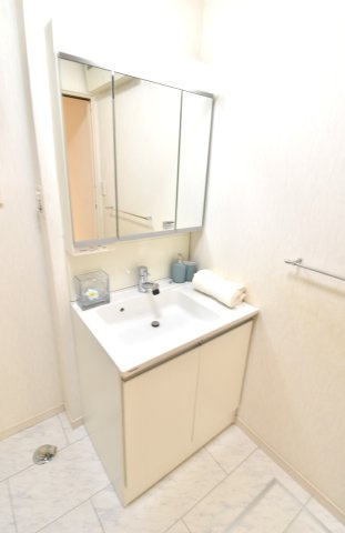 南ひな壇に建つ収納充実のモダン住宅の独立洗面台|三面鏡の裏には収納が付いています。シャワー水栓もついていてとても便利です。側面にはカウンターがあり小物を置くことも可能です。