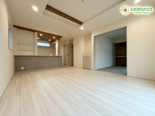 深谷市上柴町西1丁目　新築一戸建て　ブルーミングガーデン　02の居間・リビング|開放感のある広々としたLDKは、家族の団らんにぴったり! 木目調の折り上げ天井がお洒落な空間を演出しており、ダウンライトが落ち着いた雰囲気を醸し出します♪ 和室と隣接しているため、さらに広く使えます!