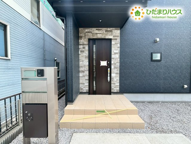 深谷市上柴町西1丁目　新築一戸建て　ブルーミングガーデン　02の玄関|高級感のある木目調の玄関ドアが、お客様をお出迎え♪ 玄関横には、ベビーカーやアウトドア用品なども収納できる便利な土間収納を設けています! 傘や靴で散らかりがちな玄関周りをすっきりと片付けられますね♪