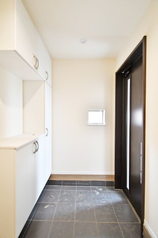 第17上尾上　全6棟　B号棟の玄関|白を基調とした天井高まであるシューズボックス付き。家族全員の靴がスッキリ収まり、清潔感溢れる空間を保てます。小窓からの柔らかな採光が、帰宅する家族を優しく迎える開放的な玄関デザインです。