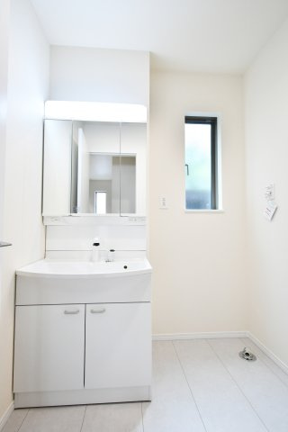 第17上尾上　全6棟　B号棟の独立洗面台|三面鏡裏の収納やゆとりある洗面ボウルが、慌ただしい朝の身支度をスムーズに。横に広がるスペースは脱衣室としての使い勝手も良く、明るい採光窓が空間をより広く、清潔な印象へと引き立ててくれます。