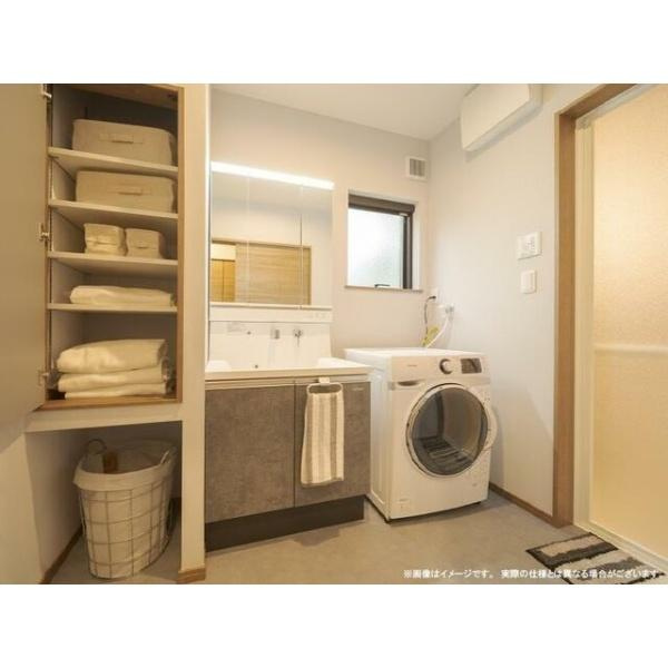 荏隈2　A棟の独立洗面台|洗面台と洗濯機が並ぶことで日々のお手入れや洗濯作業を効率的にこなせます。収納棚にはタオルや小物をすっきり整理できます。ナチュラルな色合いが空間に落ち着きをもたらします。