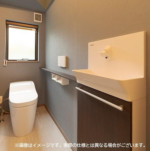 大在汐見　A棟のトイレ|落ち着いた雰囲気のトイレ空間です。大きな窓から自然光が入ります。手洗いカウンターが備わっており清潔感のあるデザインです。収納スペースも確保されています。