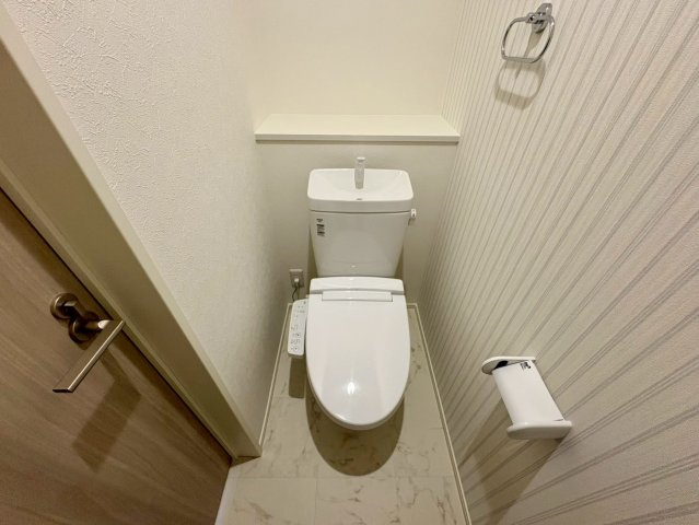「駐車３台可能」高知市鴨部8　新築一戸建てのトイレ|清潔感のある快適な温水洗浄便座付きトイレ。予備のペーパーや小物の収納に便利な棚スペースも。