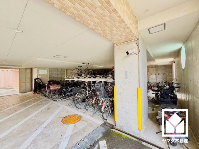 ロイヤル西宮門戸ウエストガーデンの駐輪場|サイクルラック付きの駐輪場を設置。スッキリ整理されて、自転車同士が接触・転倒しにくい設計です。屋根付きのバイク置き場もございます。