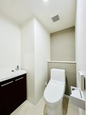 ファミール鶴見のトイレ|トイレ内にスッキリ収まる手洗キャビネットつき。温水洗浄便座は手元のパネルで操作でき使い勝手も良好。