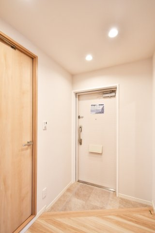 ソフィア上尾C棟の玄関|家の顔となる玄関は、大理石調タイルと柔らかな照明でホテルライクな空間に。段差を抑えた設計が住まう人に寄り添い、帰宅のたびに安らぎを感じさせます。毎日触れる場所だからこそ、質感を大切にしました。