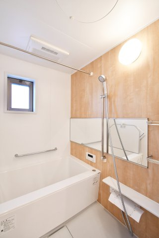 ソフィア上尾C棟の浴室|木目調パネルが安らぎを演出するユニットバスへ新規交換。横長ワイドミラーが空間に奥行きを与え、ゆったりとしたバスタイムを叶えます。雨の日の衣類乾燥にも重宝する浴室換気乾燥機付きです。