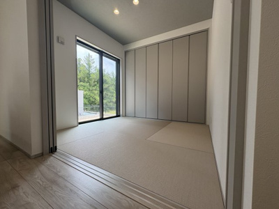 【和室】 | 建物完成！ご案内可能です＼緑に包まれたのんびり暮らしが叶う／タマタウン那珂川山田1号地 | 畳表は優しい色合いで、フローリングの色と馴染みます。和室とリビングの両方から出られるウッドデッキを設ければ、内と外がゆるやかに繋がり、家族が自然と庭へ出ていくような、のびやかな暮らしが生まれそうです。