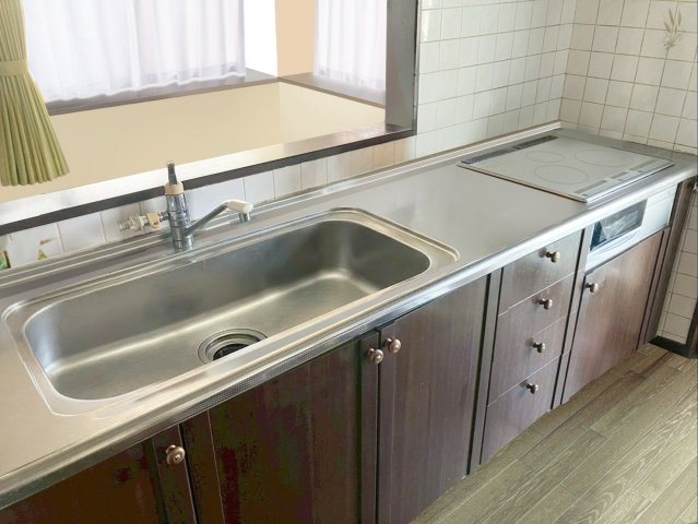 篠栗町和田３丁目 中古戸建のキッチン|お手入れ簡単なシステムキッチンです！火を使わないIHの3口コンロ！
（※AI加工により小物を消去しています）