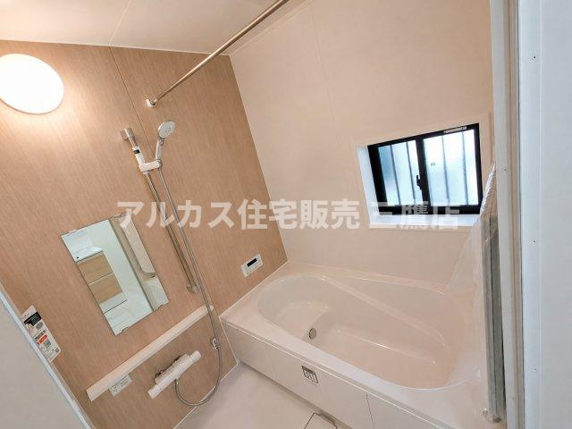 京王線 仙川駅 16分 新築戸建 三鷹市新川1丁目の浴室|温かみのあるアクセントパネルと小窓を備え、自然光が心地よい清潔感あふれるバスルーム。