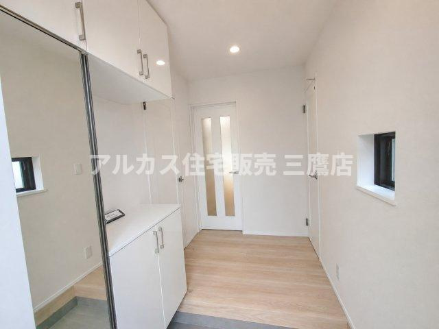 京王線 仙川駅 16分 新築戸建 三鷹市新川1丁目の玄関|全身鏡付きの大容量シューズボックスを配した、白を基調とした爽やかで清潔感のある玄関ホール。