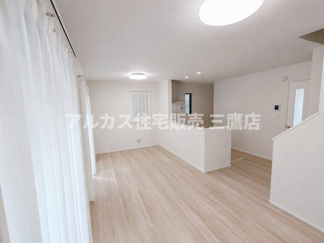 京王線 仙川駅 16分 新築戸建 三鷹市新川1丁目の居間・リビング|木目調のフローリングとホワイトの壁面が調和した、奥行きのある広々としたリビング。
⑦ キッチンからリビング全体を見渡すことができ、小さなお子様がいても安心のLDKレイアウト。