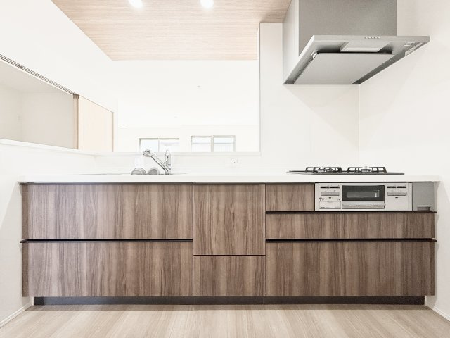 中央区萩丘4丁目　3期全2棟　2号棟のキッチン|ダークブラウンの木目が素敵なシステムキッチン！オプションで食洗器の取り付けも可能。
