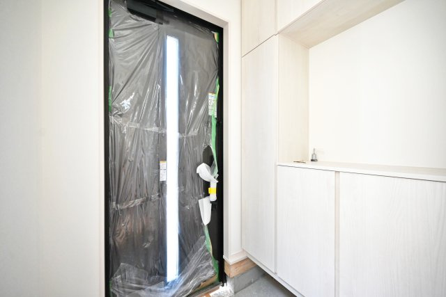 ファーストタウン伊丹市堀池2丁目新築一戸建て｜1SLDK＋駐車1台の玄関|1階玄関をホール側から撮影した内観写真です。 シンプルな玄関扉にシューズボックス、小窓を配置したオーソドックスな玄関です。
