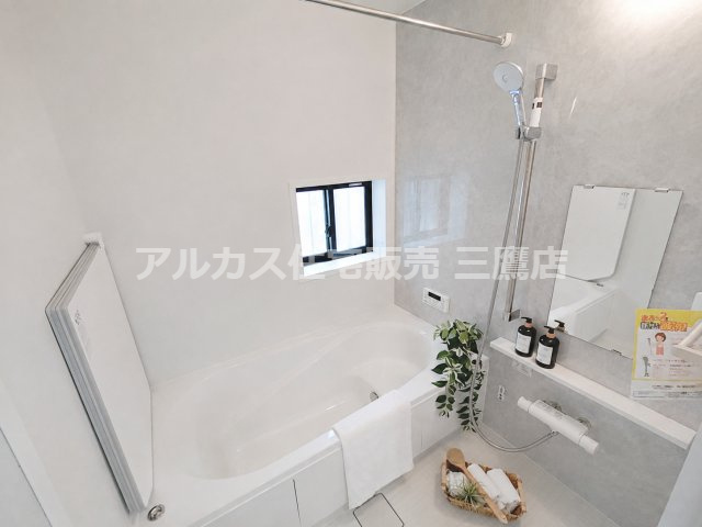 京王線 仙川駅 16分 新築戸建 三鷹市新川1丁目の浴室|小窓と鏡、物干しバーを備え、グレーの壁面が落ち着きを添える浴室です。
