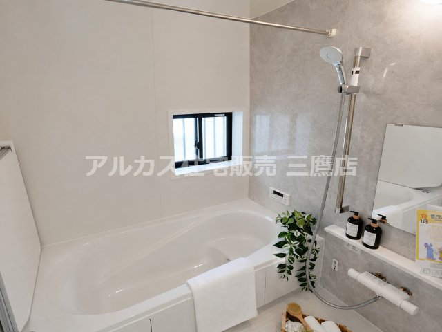 京王線 仙川駅 16分 新築戸建 三鷹市新川1丁目の浴室|小窓や物干しバーを備え、白とグレーでまとめた清潔感のある浴室です。