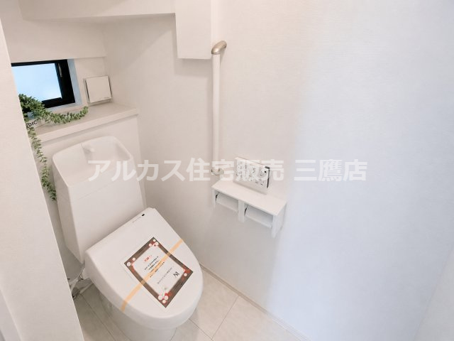 京王線 仙川駅 16分 新築戸建 三鷹市新川1丁目のトイレ|手すりと小窓、壁付けリモコンを備え、使いやすさに配慮されたトイレです。