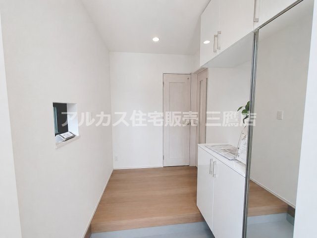 京王線 仙川駅 16分 新築戸建 三鷹市新川1丁目の玄関|小窓と大型ミラー付きシューズ収納を備え、すっきり整えやすい玄関です。