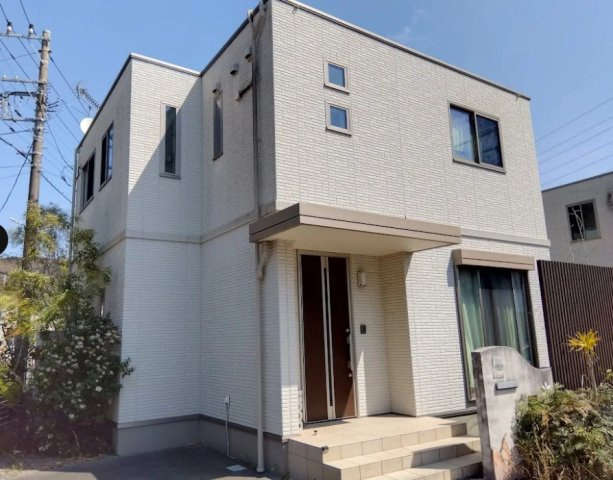 売中古戸建　三島市徳倉３丁目の外観|白を基調としたスタイリッシュな外観が印象的な2階建て住宅です。玄関には屋根があり、雨の日でも安心して出入りが可能。前面には駐車スペースも確保されており、お車をお持ちのご家庭にも嬉しいポイントです。