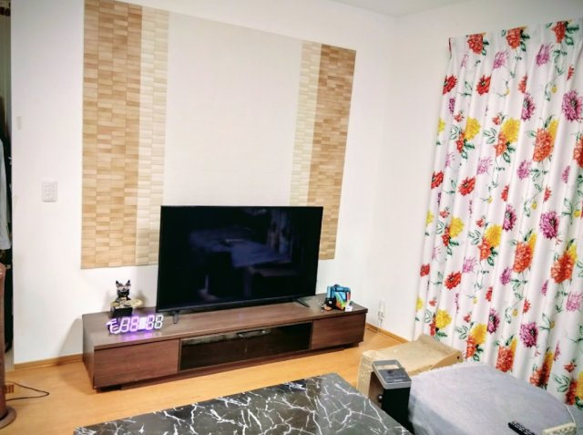 売中古戸建　三島市徳倉３丁目の居間・リビング|テレビ背面の壁に施されたデザインパネルが、お部屋のアクセントになっています。ワイドなテレビボ－ドが置ける広々としたリビングは映画観賞やゲ－ムが趣味の方にピッタリです。