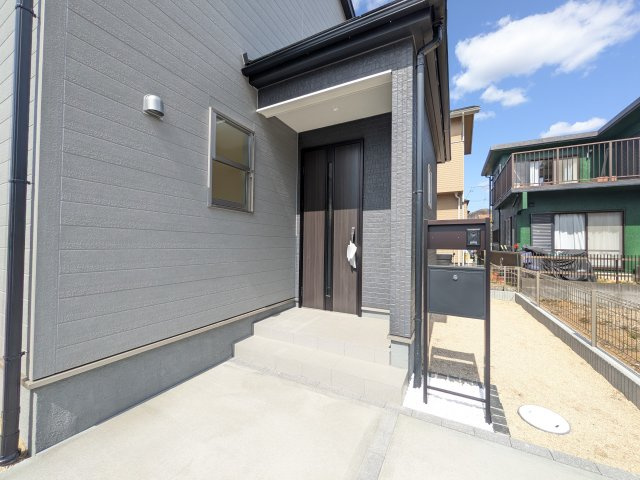 小美玉市清風台団地第6の玄関|お洒落な玄関ドアと洗練された外壁デザイン。家の顔にふさわしい上質な佇まいで、ご家族やお客様を迎えます。