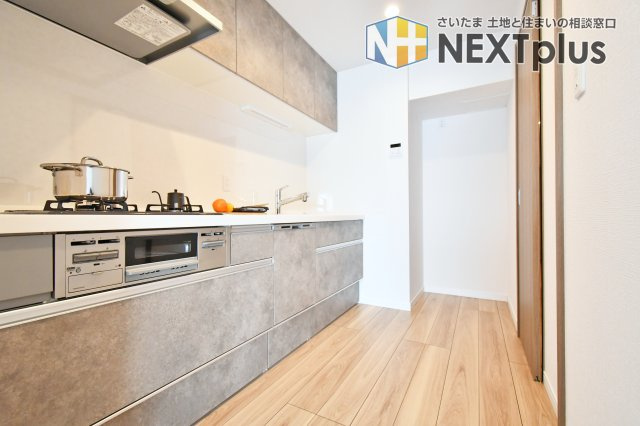 ライオンズマンション大宮指扇第二のキッチン|大理石調のお洒落なシステムキッチンで、お料理が捗りそうですね。三口ガスコンロのキッチンでは、複数調理が同時にできるので便利です。キッチンが散らかっていてもリビングからは見えづらいのもポイントですね。