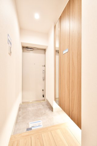 ライオンズマンション大宮指扇第二の玄関|トールタイプのシューズクロークにはご家族皆さんの靴がたっぷり収納できます。足元をやさしく照らす間接照明が、家の顔である玄関をお洒落に演出しています。全身鏡があるのでお出かけ前の服装チェックもできます。