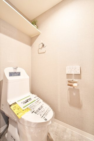 ライオンズマンション大宮指扇第二のトイレ|トイレ上部には棚が設置されているので、トイレットペーパーのストックやお掃除用品などを収納することができて空間をスッキリとお使いいただけます。シックな色味のアクセントクロスで落ち着ける空間になりますね。