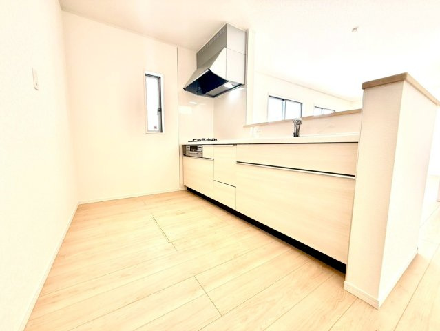 クレイドルガーデンうるま市与那城屋慶名 第６・２号棟のキッチン|会話の弾む対面式のシステムキッチン・換気窓＆床下収納付き／キッチンからリビングの眺め