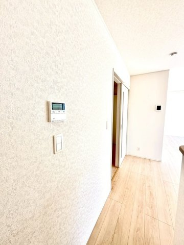 クレイドルガーデンうるま市与那城屋慶名 第６・３号棟のその他|リビングに設置された給湯器リモコンとインタフォーンパネル
