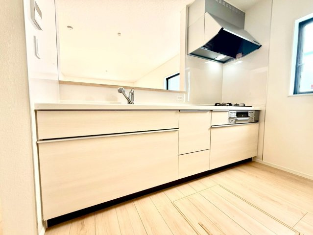 クレイドルガーデンうるま市与那城屋慶名 第６・４号棟のキッチン|レンジフード＆ガスコンロ３口＆備え付け収納付きのシステムキッチン