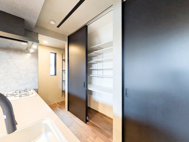 大森町新築戸建のキッチン|キッチンの裏には大容量の収納棚、横にはパントリーがございます。