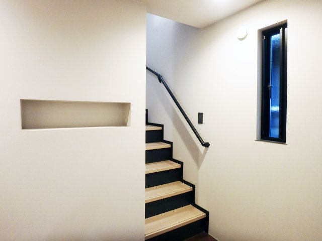 大森町新築戸建の玄関|玄関に入ると正面にニッチがございますので、写真や観賞用植物を置いていただくことができます。踏板と蹴込部分を異なるカラーリングにしているため、お洒落な階段に仕上がりました。
