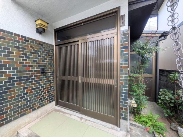 上田町3丁目　戸建ての玄関|シンプルで落ち着いた雰囲気の玄関です。ガラス入りの引き戸デザインが印象的です。周囲のタイル壁がアクセントとして空間に個性を与えています。