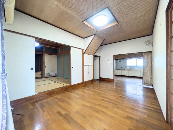 上田町3丁目　戸建ての居間・リビング|広々としたリビング空間が広がり隣接する和室とのつながりも魅力的です。天井のデザインが個性的で明るい照明が印象的です。開放感のあるレイアウトで快適にお過ごしいただけます。