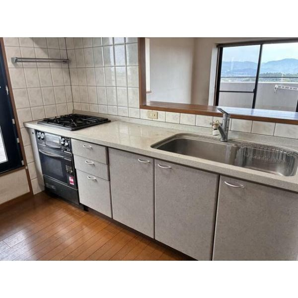 ライフヒルズ明野南のキッチン|キッチンは広々とした作業スペースが確保されています。三口コンロと大きめのシンクが設置されています。窓からの光が入る明るい空間です。タイル壁面でお手入れが簡単です。使いやすい収納も豊富に備わっています。