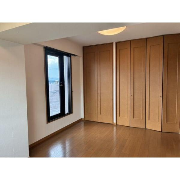 ライフヒルズ明野南の洋室|落ち着いた色合いのフローリングが印象的な洋室です。大きな窓から自然光が入り室内が明るく感じられます。クローゼット収納も充実しておりすっきりとした空間を保てます。