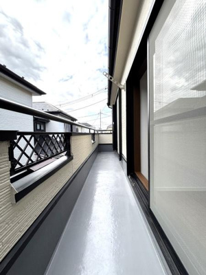 【バルコニー】 | 草加市青柳6丁目・戸建 | 奥行きのあるバルコニーが特徴です。高めの手すりが安心感を与えます。明るい光が差し込み開放感を楽しめるスペースです。両側の壁もスタイリッシュな印象です。