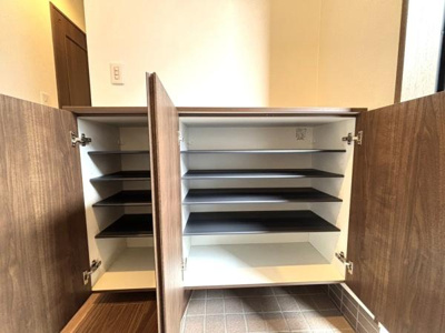 【玄関】 | 草加市青柳6丁目・戸建 | 玄関には大容量の収納スペースが設けられています。シンプルなデザインが空間をすっきりと見せてくれます。扉は開閉しやすく使い勝手にも配慮されています。靴や小物の整理がしやすい棚板も備えています。