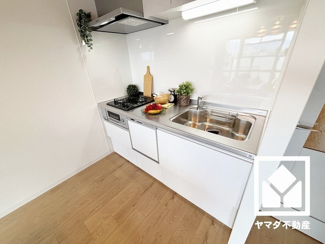 鳴尾小松住宅A棟のキッチン|キッチンは空間を有効活用できる壁付けタイプ。明るい白色で統一された清潔感のあるデザインが魅力のシステムキッチンです。