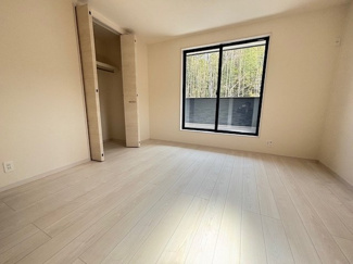 【洋室】 | 東広島市高屋町高屋堀（全2区画）2号棟 | バルコニーに面した掃き出し窓のある主寝室候補。明るい色のフローリングが空間をより広く感じさせます。クローゼットも完備しており、家具を最小限に抑えたゆとりある空間作りが可能です。