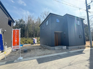 【外観】 | 東広島市高屋町高屋堀（全2区画）2号棟 | シックなダークトーンの外壁が目を引く外観。周辺は落ち着いた住環境で、建物の前にはゆとりあるスペースを確保しています。青空に映えるモダンなシルエットが、日々の帰宅を心地よく迎えてくれます。