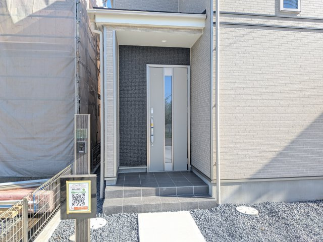 ひたちなか市足崎1474番　新築戸建て　B号棟の玄関|お洒落な玄関ドアと洗練された外壁デザイン。家の顔にふさわしい上質な佇まいで、ご家族やお客様を迎えます。
