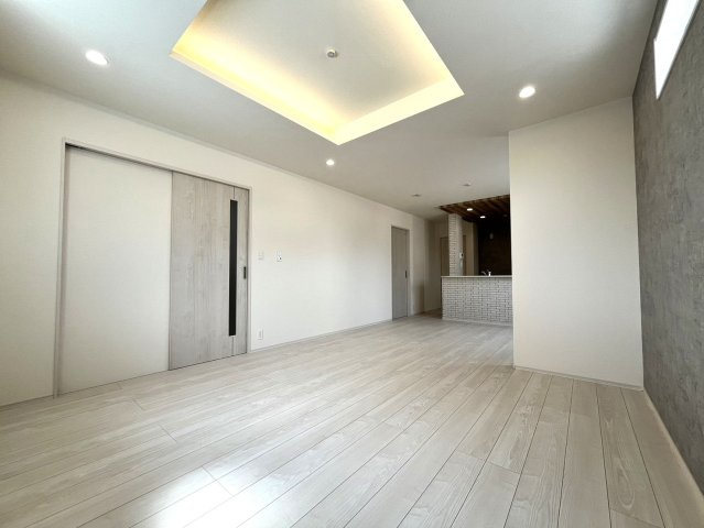神戸市垂水区名谷町　新築戸建ての居間・リビング|デザインクロスと高配天井でおしゃれな空間を演出　家具の色も合わせやすいホワイト系の木目のフローリングです♪