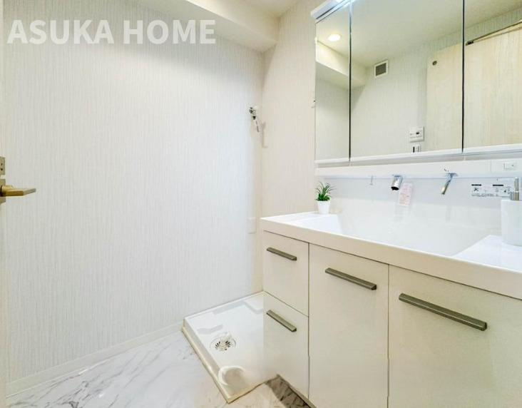 第2磯子ハイツの独立洗面台|リノベーションされた脱衣場は新規交換された洗面化粧台配置されています。